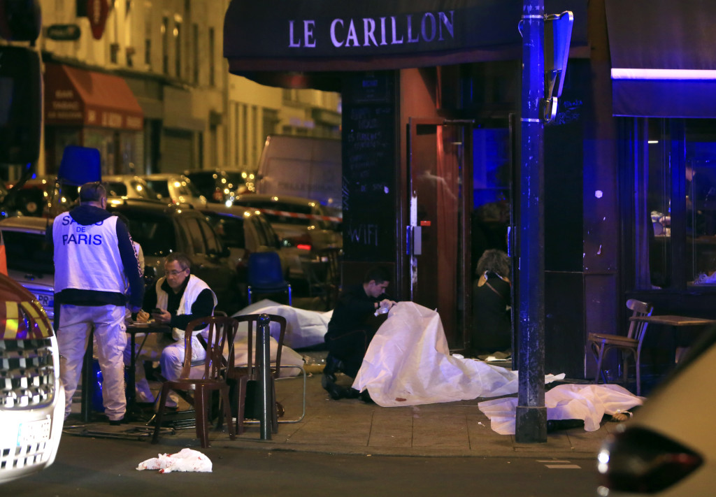 Victims lay on the pavement in a Paris restaurant, Friday, Nov. 13, 2015. Police officials in France on Friday reported a shootout in a Paris restaurant and an explosion in a bar near a Paris stadium. It was unclear if the events were linked. (AP Photo/Thibault Camus) NYTCREDIT: Thibault Camus/Associated Press